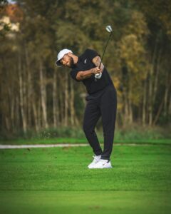 A middle-aged golfer practicing their swing indoors on a golf simulator, focusing on alignment and grip.